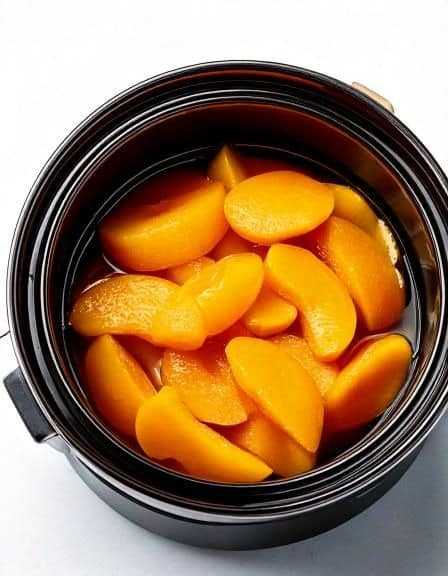 Put canned peaches in a slow cooker with these 3 ingredients. Dessert dreams come true.